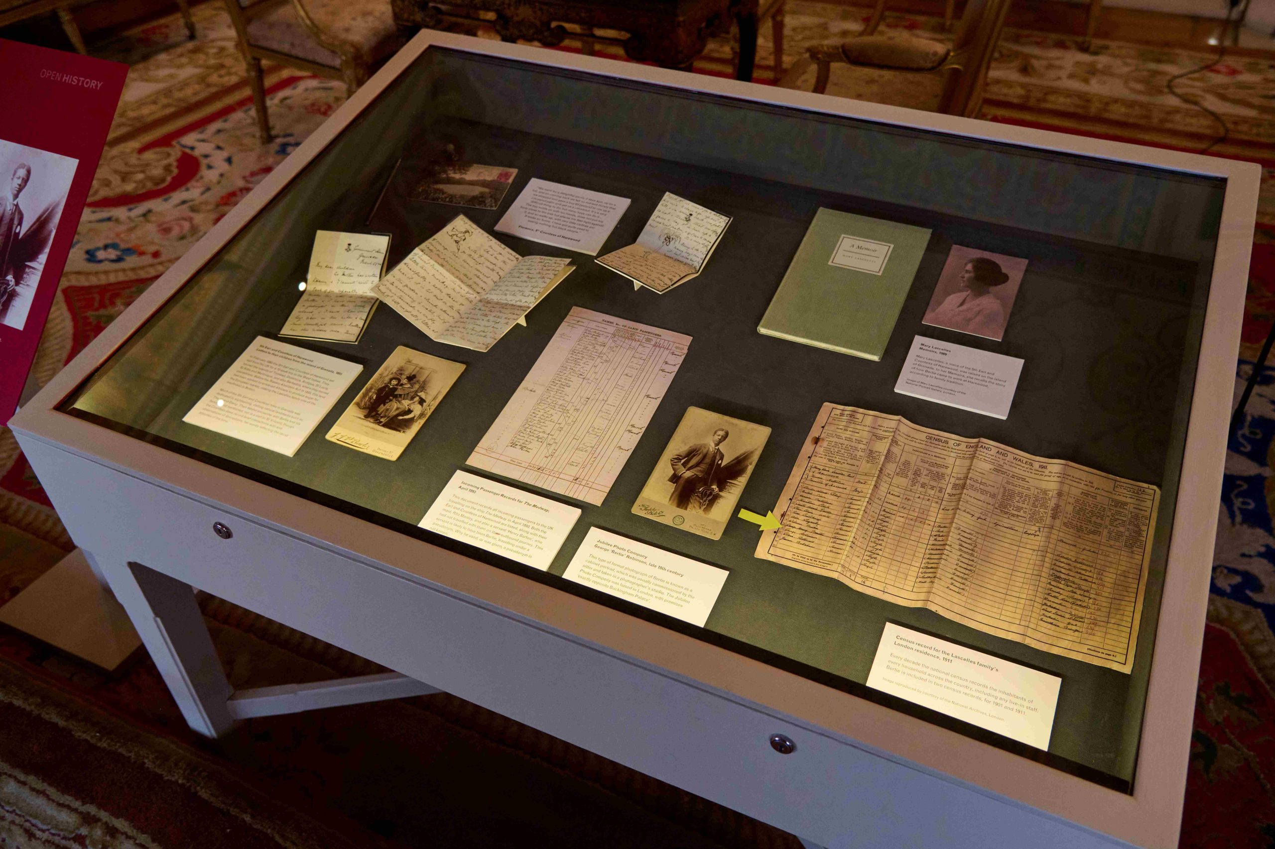 A white display case with dark blue liner photographed on an angle. The case is filled with various historical documents and photographs relating to Bertie Robinson.