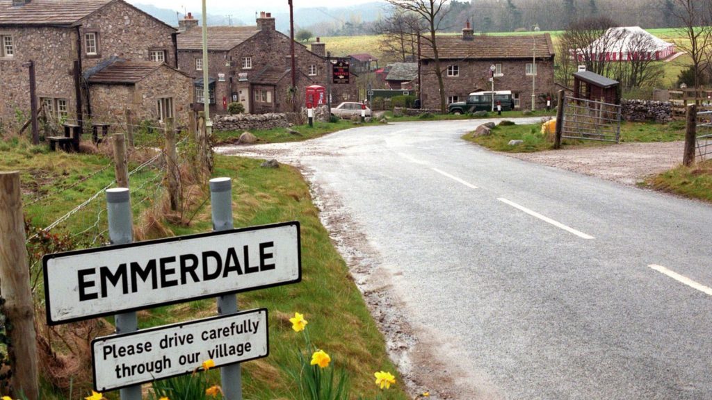 Emmerdale village sign to the left of a road leading into the custom built village on Harewood Estate.