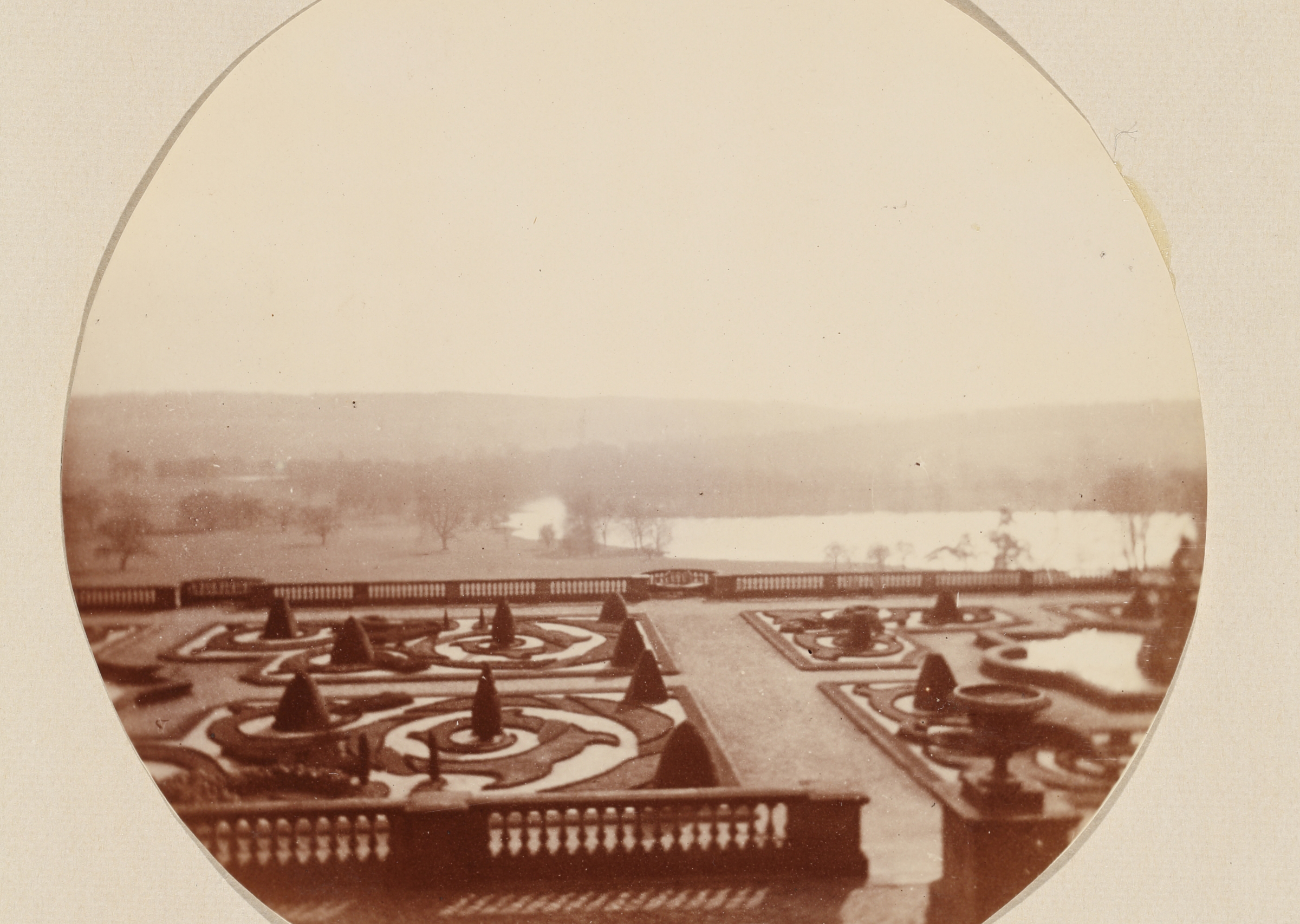 Sepia photograph of the intricate design of the Victorian Terrace with Capability Brown lake and landscape in the background.