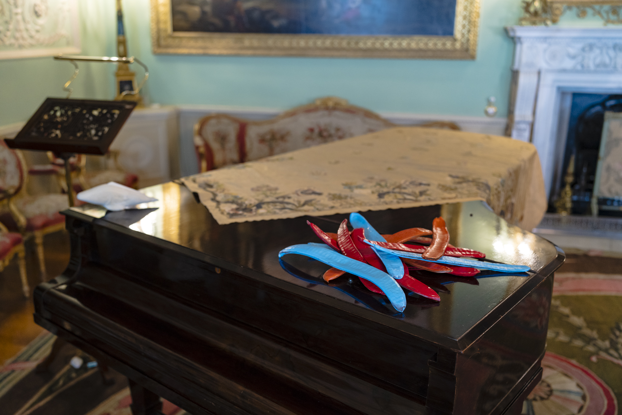 Handmade leather blue, red and orange tamarind fruit are placed on top of the grand piano in Harewood Music Room