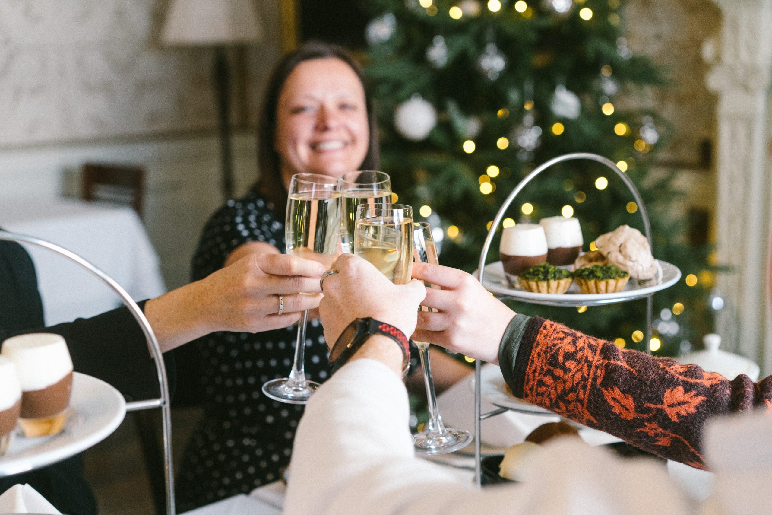 Group of friends cheers with glasses of fizz before tucking into a Festive Afternoon Tea in the Billiard Room at Harewood