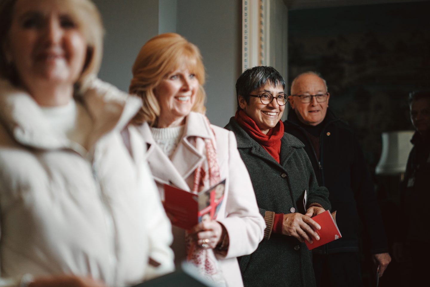 A group of four people holding Harewood guide books enjoying a private tour of the State Floor.