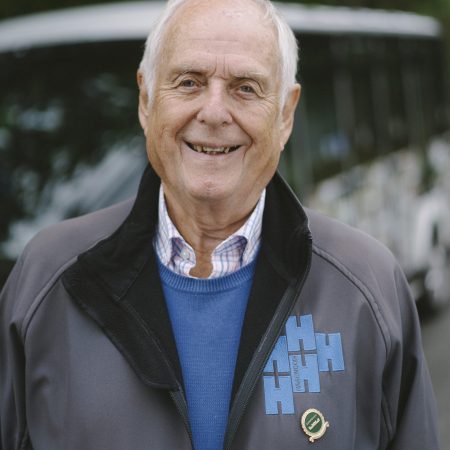A caring and helpful person wearing a volunteer Harewood fleece decorated with a long service award pin badge.