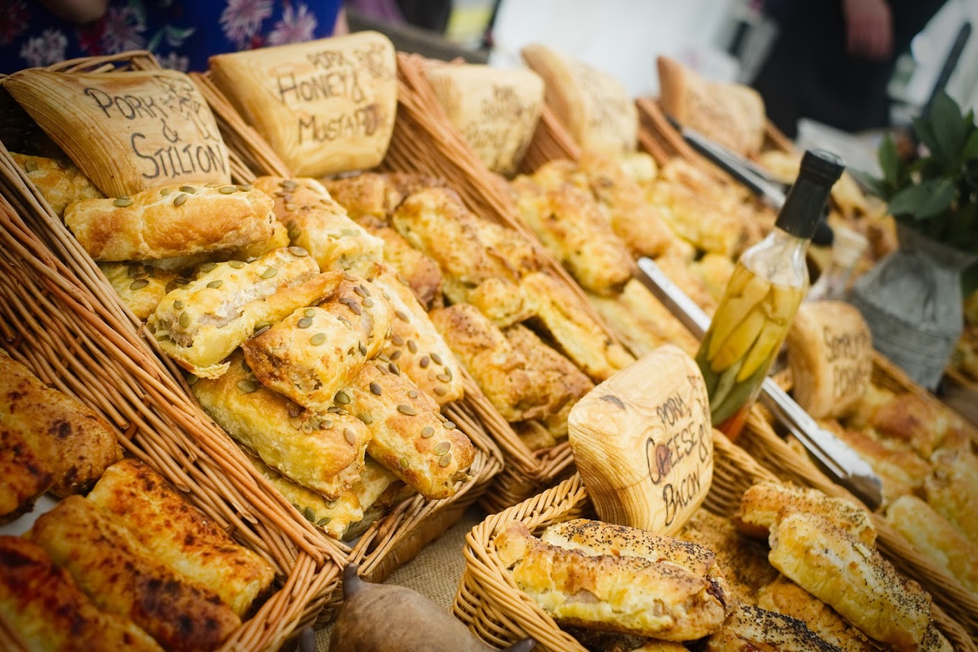 A table arranged with various baskets filled with an assortment of pastries and sausage rolls