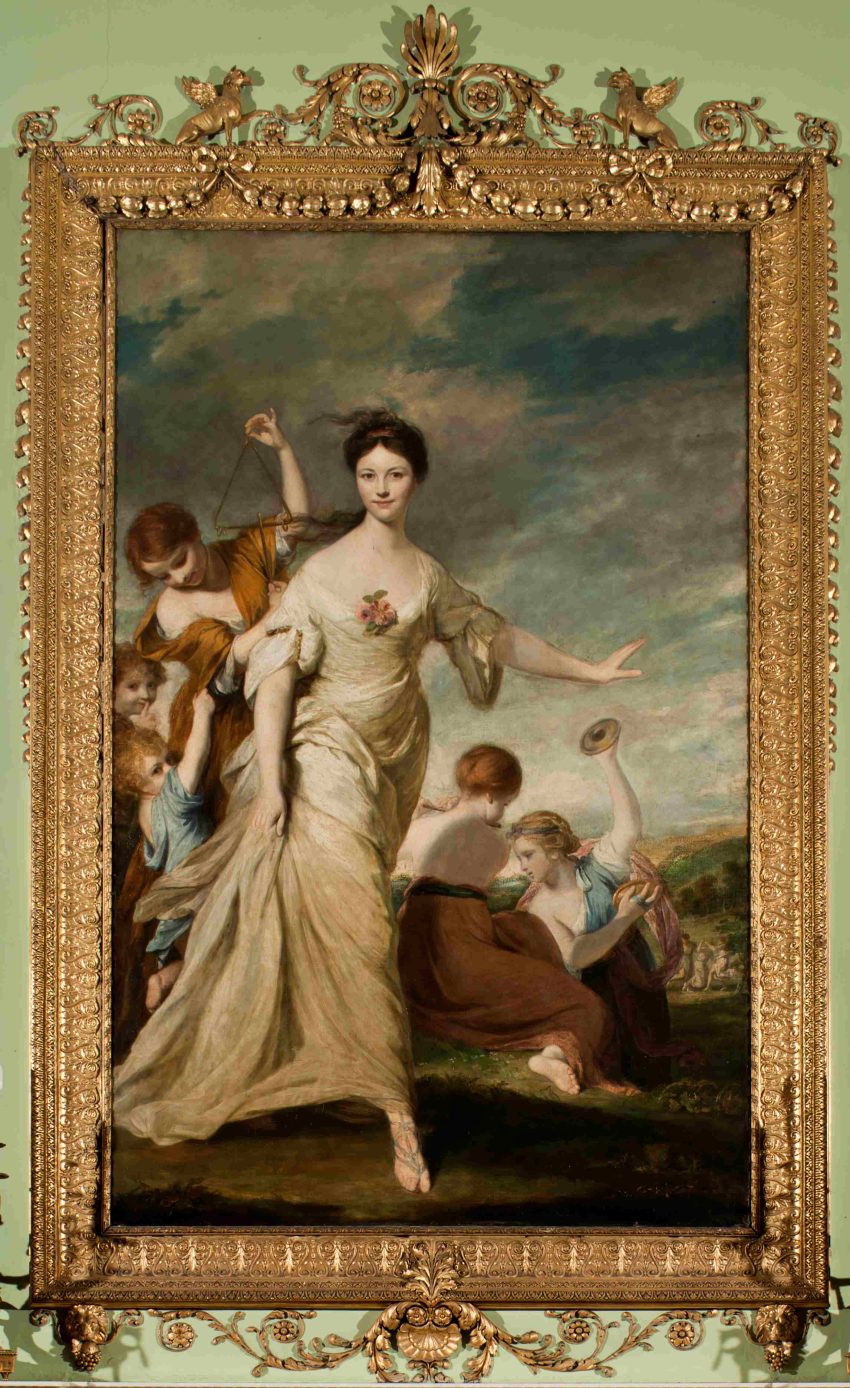 A full length portrait of a white woman in her 20s. She is shown in a white flowing gown in a dancing motion with her left hand flung out for balance. Behind her is a landscape with many children playing musical instruments arranged in a triangular composition.